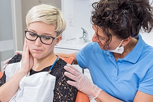 Woman in pain being comforted by dentist