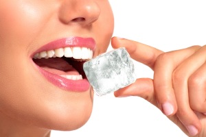 Patient in Austin biting ice with dental implants