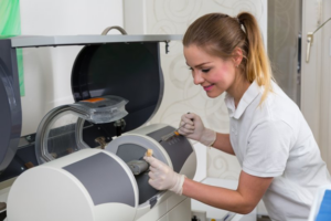 Dentist operating a CEREC machine and inserting the porcelain block