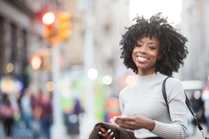 Woman in sweater walking down street and smiling